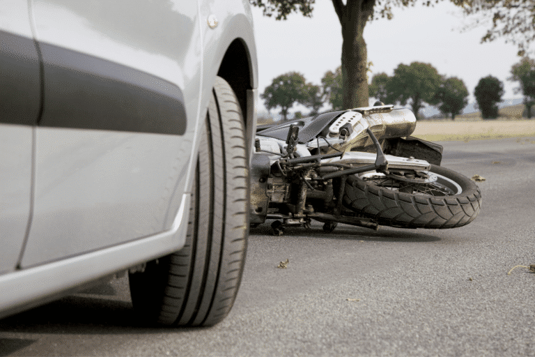 Motorcycle on ground after collision with car