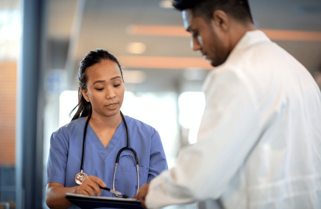 Photo of a nurse reviewing charts with a doctor