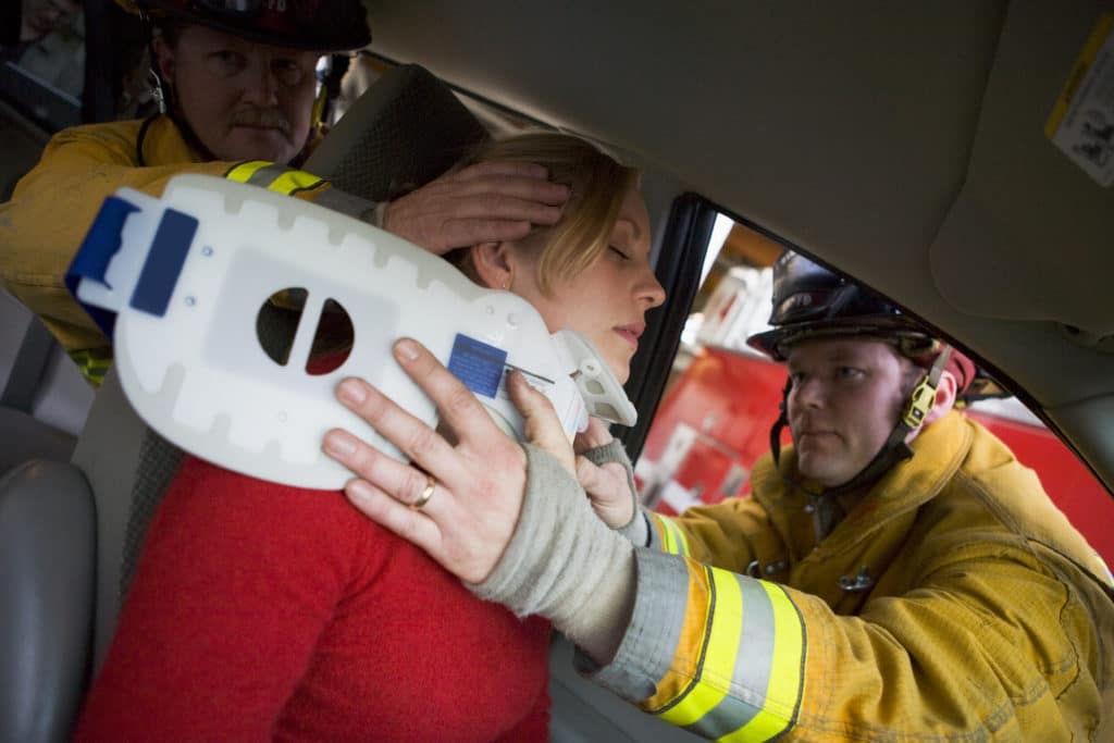 firemen helping a woman with neck spine injury