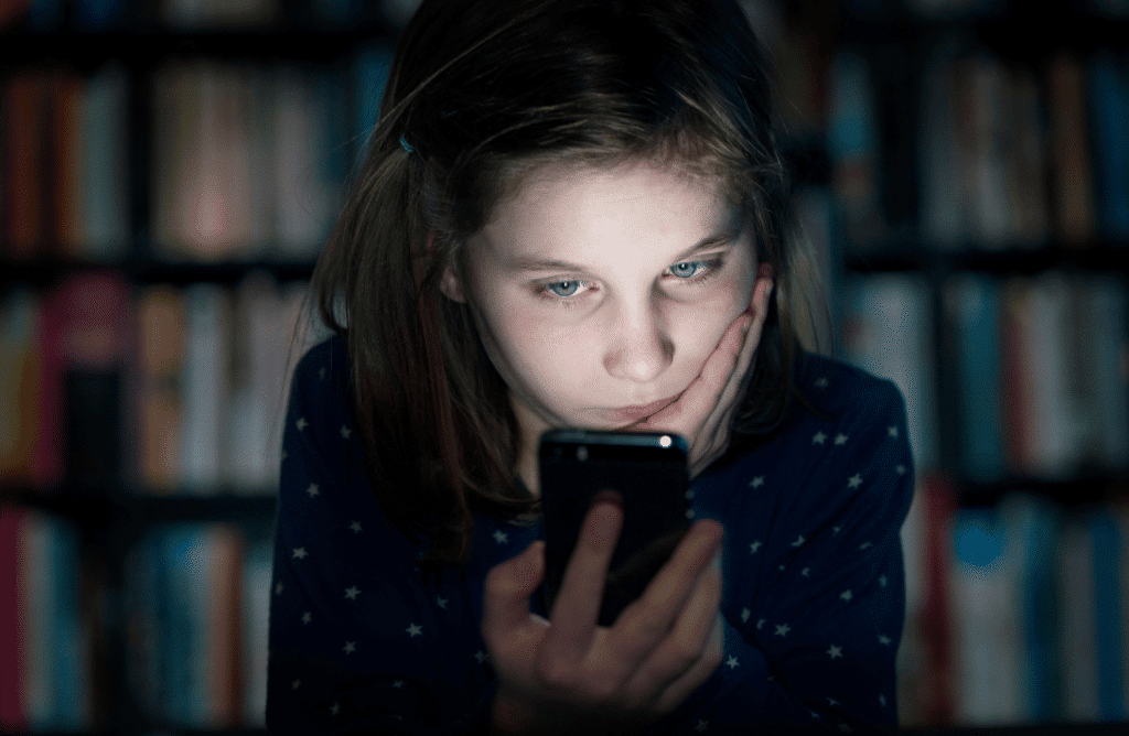 A teenager with her phone scrolling through social media apps