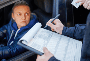 Man with clipboard speaking with a driver
