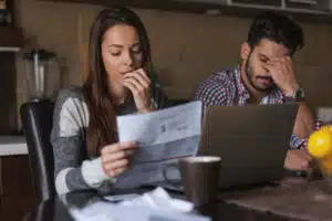 Two people looking upset as they review paperwork