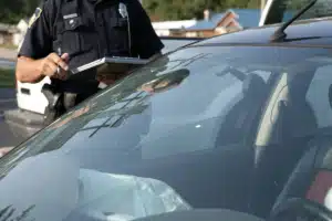 Officer reviewing a car with clipboard in hand