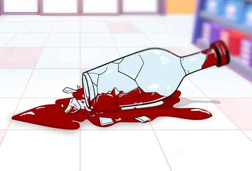 Broken bottle spilling liquid on floor