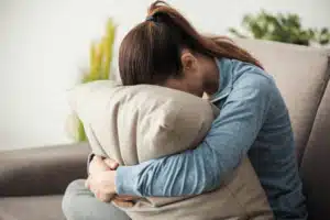 Woman with face buried in pillow