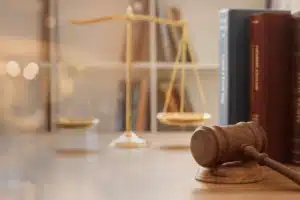 Gavel on desk with justice scales behind it