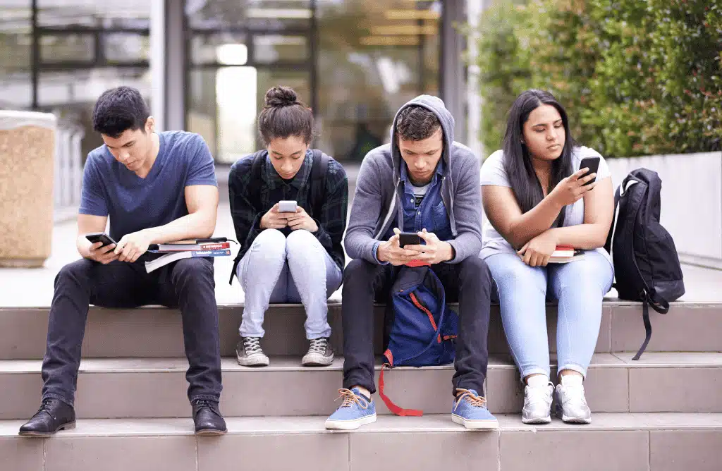 Four teens on their phones using social media