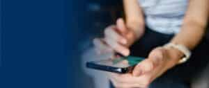 A closeup of a person's hands holding a smartphone, with their finger scrolling the screen