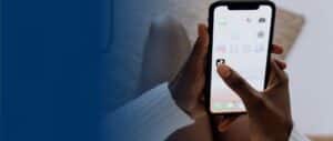 A person holding a smartphone and tapping the TikTok app icon on the screen
