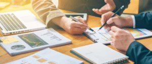 Close up of business people working over spreadsheets and paperwork