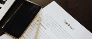 Close up of a contract on a table with a phone and pencil on it